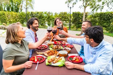 Happy friends having fun at pool terrace drinking red wine  young people to.. Stock Photos