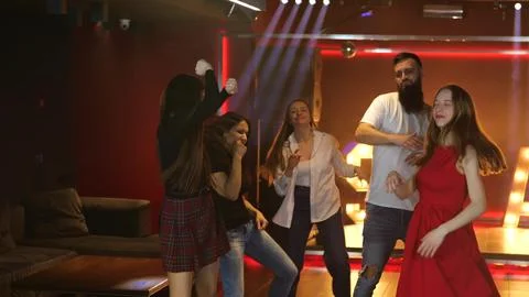 Happy friends having fun while spending time in the nightclub while dancing Fotos Stock