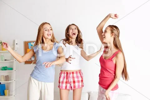 Happy friends or teen girls having fun at home Stock Photos