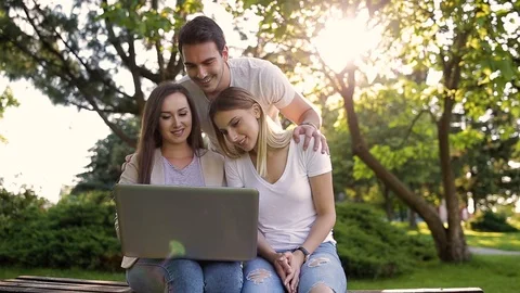Happy friends in park using ther laptop and enjoying the day Stock Footage 87389247