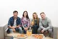The happy friends with a pizza and drinks sit on the white background Photo