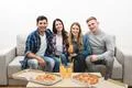 The happy friends with a pizza and drinks sit on the white background Photo