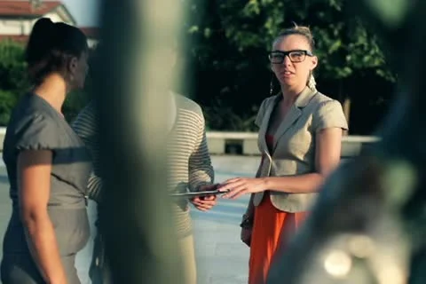 Happy friends with tablet computer looking at sculpture and talking, outdoors Stock Footage