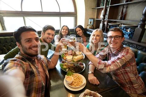Happy friends taking selfie at bar or pub Stock Photos