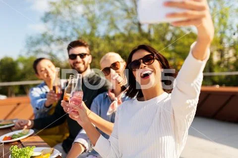 Happy friends taking selfie at rooftop party Stock Photos