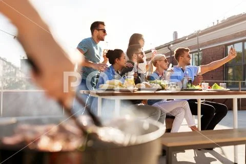 Happy friends taking selfie at rooftop party Stock Photos