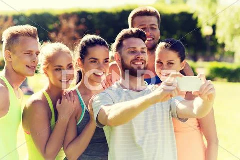 Happy friends taking selfie with smartphone Stock Photos