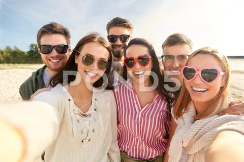 Happy friends taking selfie on summer beach Stock Photos