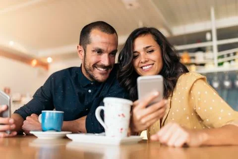 Happy friends using mobile. Stock Photos