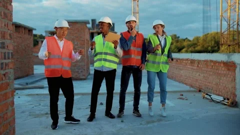 Happy funny Multi ethnic team dancing stand on construction at sunlight survey Stock Footage 139342415