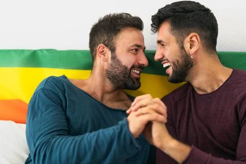 Happy gay couple having tender moments in bedroom Stock Photos