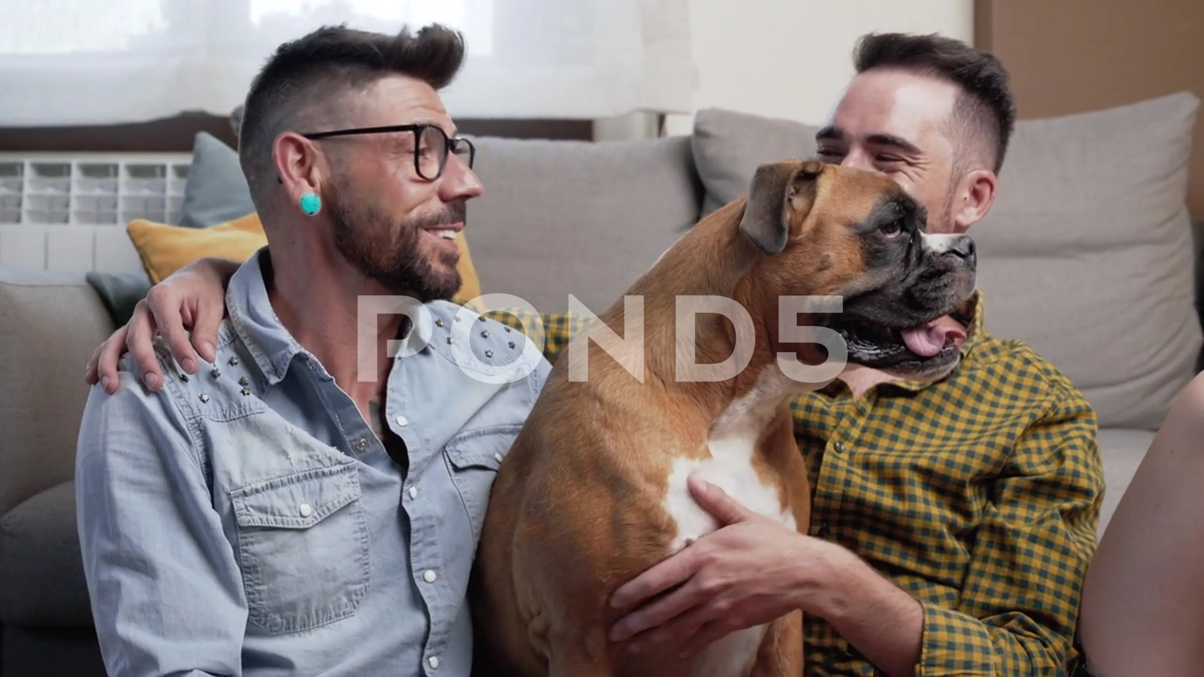 Happy gay couple sitting on floor and playing with dog at home