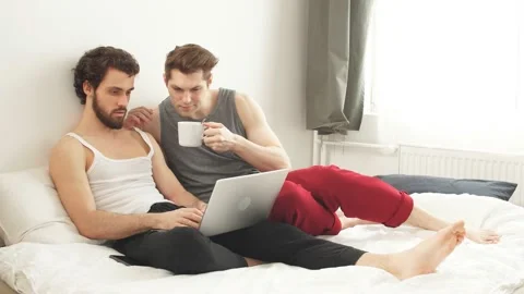 Happy gay couple using tablet in bed. gay couple Stock Footage 127019592