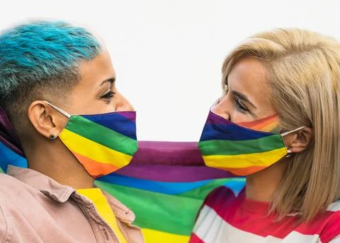 Happy gay couple wearing face mask celebrating gay pride event Stock Photos