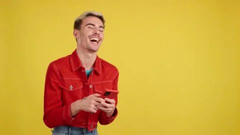 Happy gay man smiling while using the mobile Stock Footage 240605370