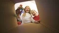The happy girl and a boy open the box near the christmas tree 4k or 4k+ Resolution