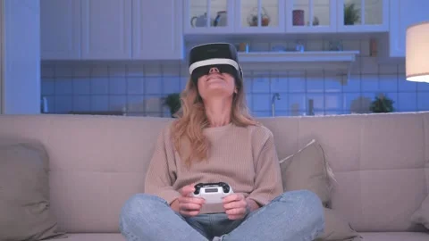 Happy Girl with Console Controller and VR Headset Plays Game in Virtual Reality Stock Footage 243620794