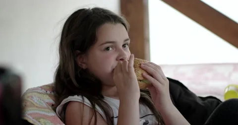 Happy Girl Eats Big Appetizing Hamburger at Veranda Vidéo 64767238