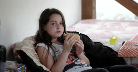 Happy Girl Eats Big Appetizing Hamburger at Veranda Stock Footage 64767244