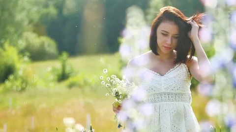 Happy girl in a field with flowers in nature. girl in a field smiling woman Stock Footage