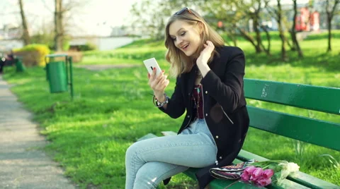Happy girl having a videocall while sitting in the park Stock-Footage 62438688