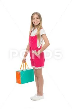 Happy girl hold shopping bag isolated on white. Little shopaholic smile with Stock Photos