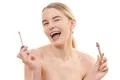 The happy girl holding a lip gloss on the white background Photo