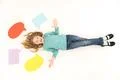 The happy girl lay on the floor near the dialog signs. View from above Photo