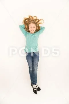 The happy girl lay on the floor. View from above Stock Photos