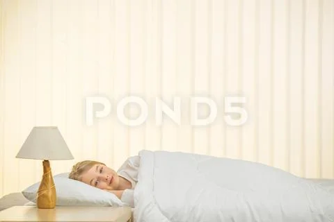 The happy girl lie on the bed Stock Photos