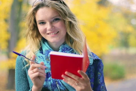 Happy girl in the park doing notes in her notebook Stock-Footage 44789082