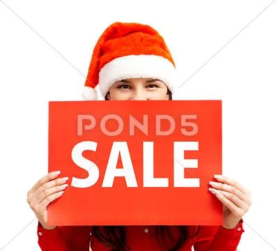 Happy girl in santa cap holds card with symbol of sale Stock Photos