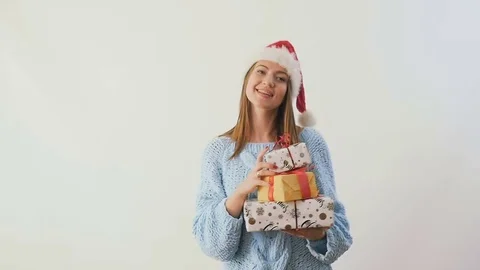 Happy girl in santa's hat dances with gifts at white background in slowmotion Stock Footage