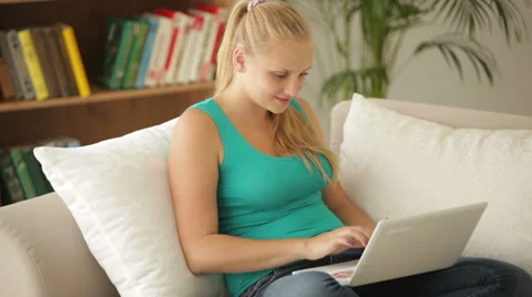 Happy girl sitting on sofa using laptop with credit card Vidéo 27692887