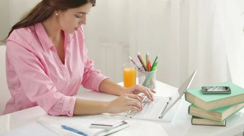 Happy girl sitting at table using laptop holding credit card looking at camera Stock Footage 34339604