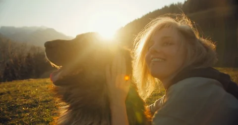 A happy girl smiling while cuddling her big fluffy beautiful dong in the sunset  Stock Footage 129405345