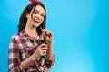 The happy girl standing with a bottle of drink on the blue background Photo