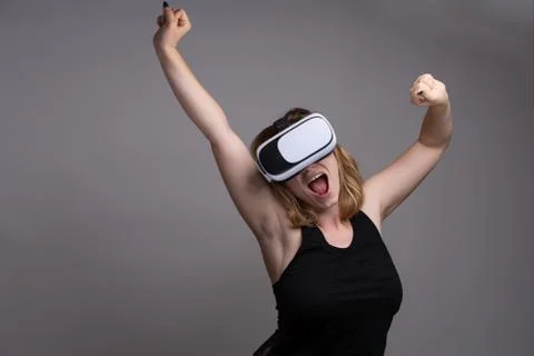 Happy girl stretching while using a 3D VR wearable gadget Stock Photos