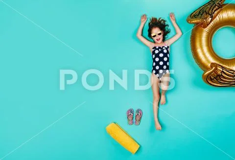 Happy girl in swimsuit lying on blue background Stock Photos