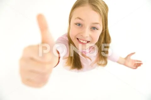 The happy girl thumbs up to the camera. View from above Stock Photos