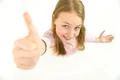 The happy girl thumbs up to the camera. View from above Photo