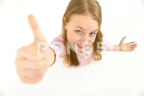 The happy girl thumbs up to the camera. View from above Stock Photos