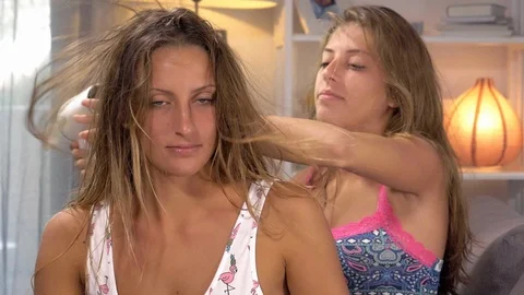Happy girlfriends having fun laughing drying long hair at home slow motion cl Stock Footage 85818823
