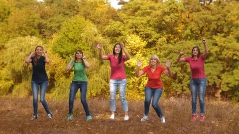 Happy girlfriends jumping on nature Stock Footage
