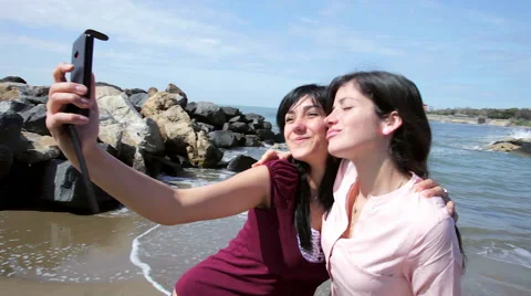 Happy girlfriends taking selfie with cell phone in front of ocean Stock Footage 60383607