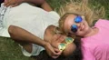 Happy girls in sunglasses lying on grass, enjoying summer holidays, vacation 4k or 4k+ Resolution