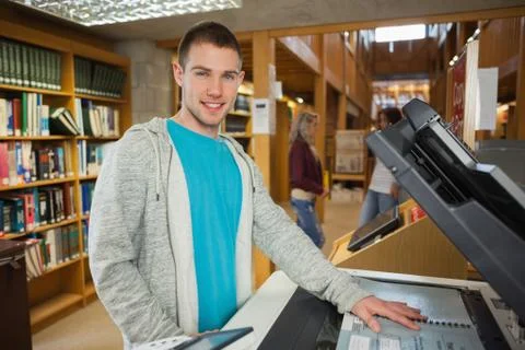 Happy good looking student using photocopier 写真素材