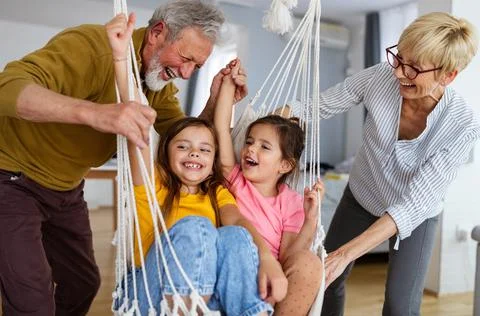 Happy grandparents having fun times with children at home Stock Photos