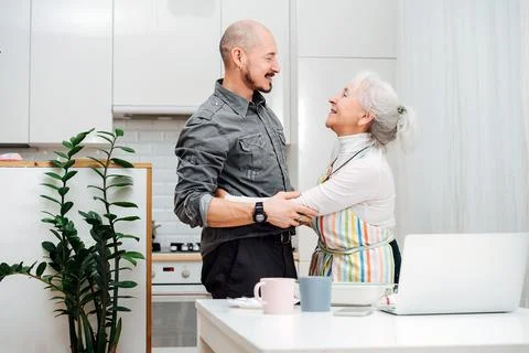 Happy granny and her son holding each others arms, greeting each other Stock Photos