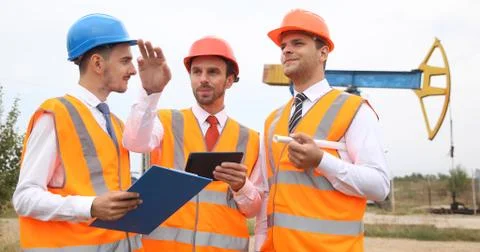Happy Group of Engineers Men Planning Activity Pumpjack Oil Pump Installation Stock Photos